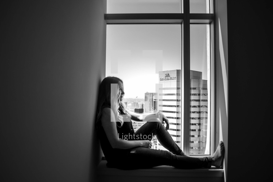 a woman sitting in a window 