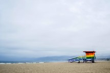 rainbow colored lifeguard stand on a beach 