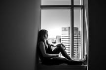 a woman sitting in a window 