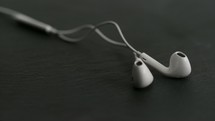 earbuds falling on black background.