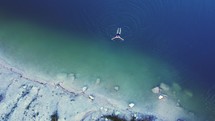Aerial top view of blue lake, swimming in water