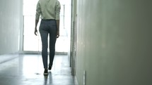 woman walking down a hallway 