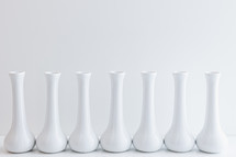 Row of empty white vases on a white background with copy space