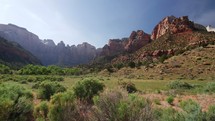 green landscape and red rock peaks 