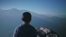 Young man at the edge of a mountain