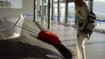 Travel woman waiting at the airport next to luggage, check the case on conveyor belts.