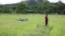 DJI Mavic Air 2 taking off on a rice paddy fields in Philippines countryside with a farmer out of focus on the background 