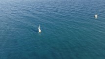 Aerial View of small sailboat sails in the sea