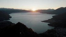 Calm Lake Water And Mountains In Rostro Maya, Guatemala At Sunset - aerial drone shot	
