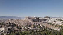 Drone flying towards iconic Acropolis of Athens on sunny day, Greece