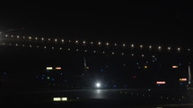 Airplanes taxiing on a runway at the airport at night