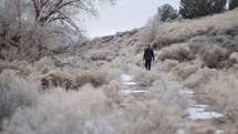 a man walking down a frozen path 