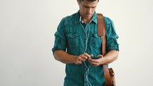 a man listening to his phone with earbuds 