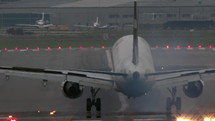 View from behind of an airplane landing on a runway.