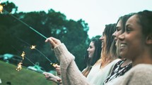 women holding sparklers 