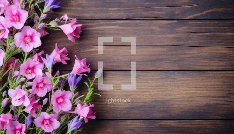 Bouquet of pink and purple flowers on a wooden background.