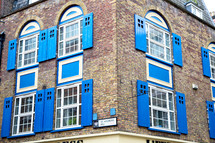 blue shutters on a brick building 