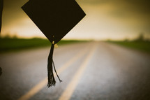 Graduate's cap and tassle hanging over the middle of the road.