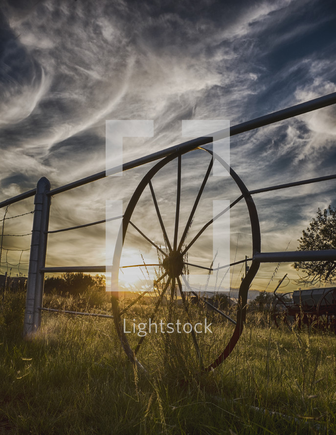 wagon wheel fence and wispy clouds 