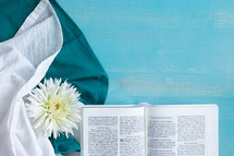open Bible on a blue background with linens 