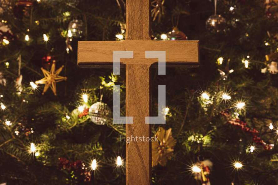 Wooden cross in front of a Christmas tree