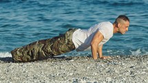 Soldier does push ups on the beach