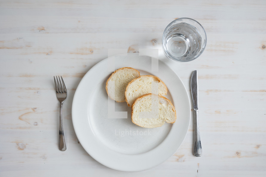 Bread and water meal on a white wood table