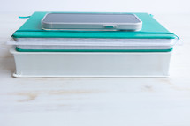 teal journal and white Bible with smartphone 