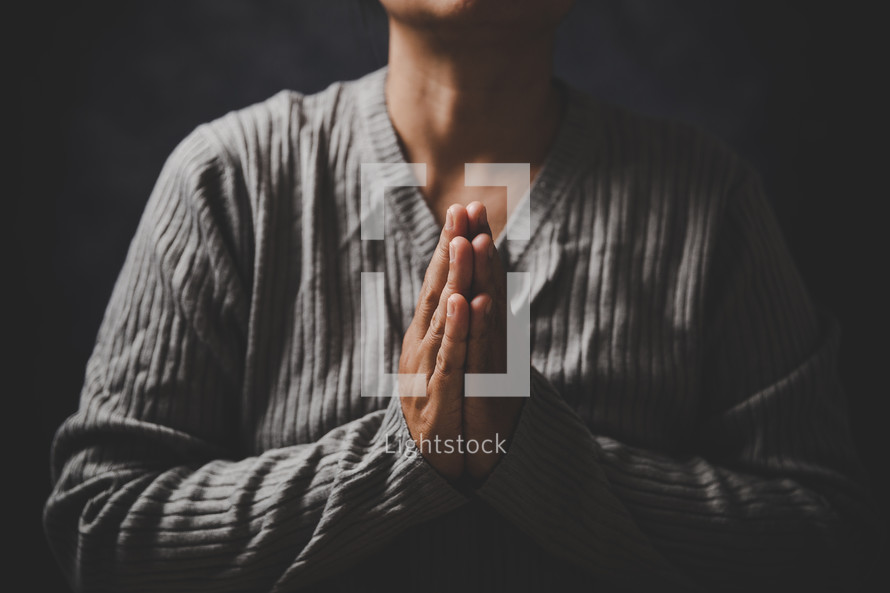 Asian woman praying with her Bible
