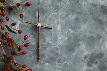cross and red berries on gray