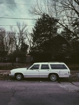 a station wagon parked in front of a house 