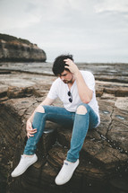 a man sitting on a rocky shore in Australia 