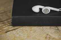 White ear buds on a Bible.