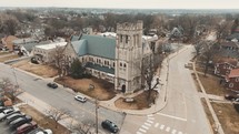 Aerial footage circling a cathedral/catholic church on a street corner