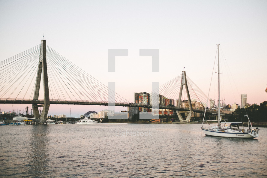 a sailboat and a bridge 