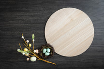 Round wood tray with  easter eggs and nest