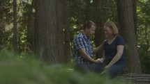 a couple praying together in the woods 
