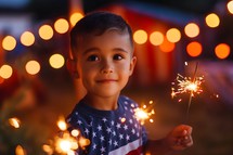 Boy holding sparkles on 4th of July celebration