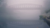 Bridge on river in the misty morning
