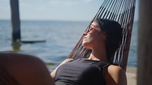 Peaceful young woman relaxing in a hammock on vacation.