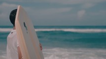 a boy with a boogie board on a beach 