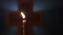 Extreme Close-up of Holy Cross with Candle.
