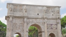 Arch of Constantine on background of blue sky on sunny day, located between coliseum and Arch of Titus on Roman road, built to celebrate triumph of
