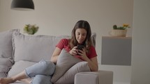 Millennial woman looking at smartphone surfing social media app. 
