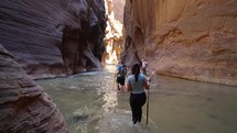 Young Woman on Hiking Adventure in the Narrows Slot Canyon in Zions, Utah
