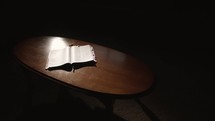 light shining on the pages of a Bible on a table 