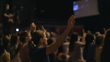 Woman worshiping with hands raised in praise and worship