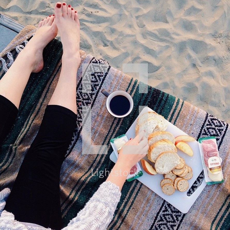 having a picnic on a blanket at the beach 