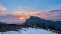 Sunset in a mountain landscape with the last snow on the meadow