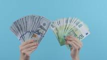 Woman with cash money - USD and EUR currency dollars euros banknotes on blue background. Jackpot, lottery prize, salary, profitable investment. High quality 4k footage